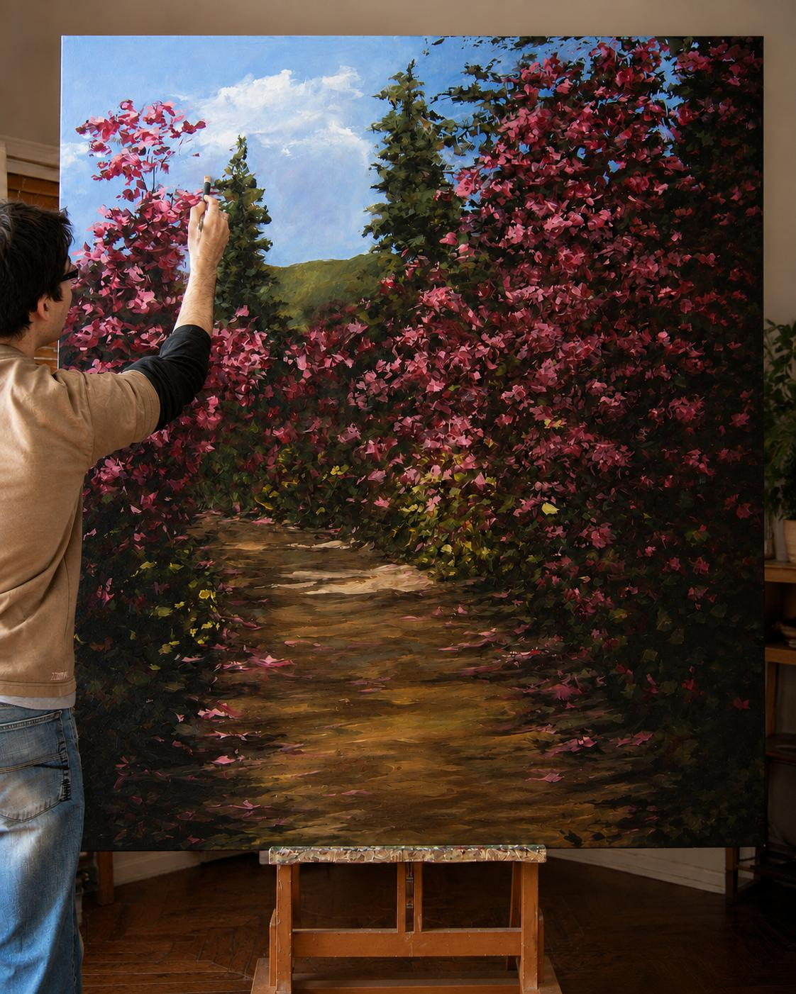Tiago Garcia a pintar a óleo, num cavalete, uma estrada ladeada de azáleas em flor